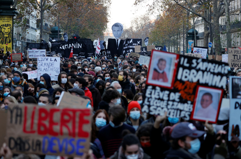 People with banners and posters attend a demonstration against the "Global Security Bill' that rights groups say would make it a crime to circulate an image of a police officer's face and would infringe journalists' freedom in France, in Paris, November 28, 2020. REUTERS/Christian Hartmann