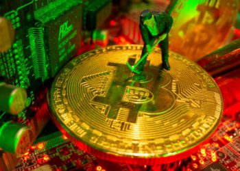 FILE PHOTO: A small toy figure and representations of the virtual currency Bitcoin stand on a motherboard in this picture illustration taken May 20, 2021. REUTERS/Dado Ruvic/Illustration/File Photo